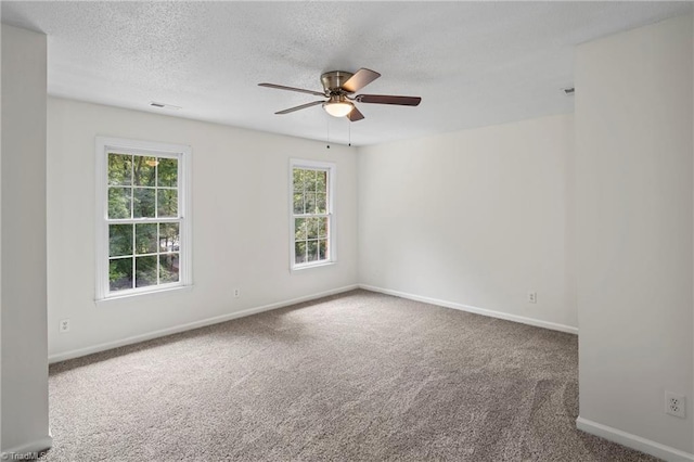 empty room with carpet floors, a textured ceiling, plenty of natural light, and ceiling fan