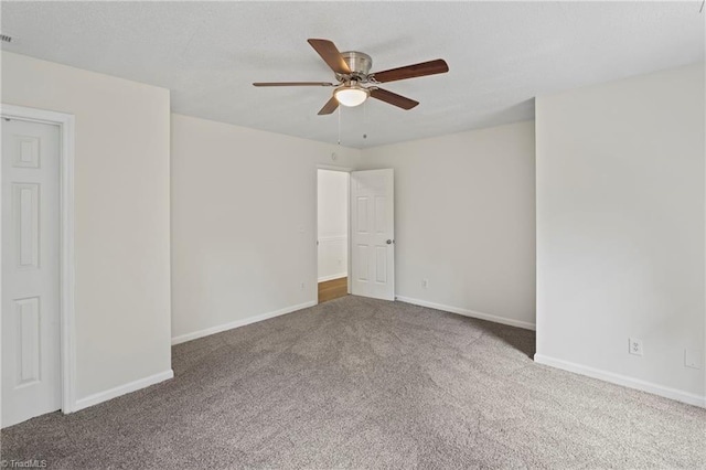 carpeted spare room featuring ceiling fan