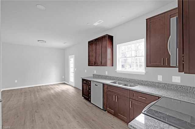 kitchen with light stone counters, sink, stovetop, light hardwood / wood-style flooring, and dishwasher