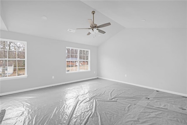 carpeted spare room with plenty of natural light, ceiling fan, and lofted ceiling