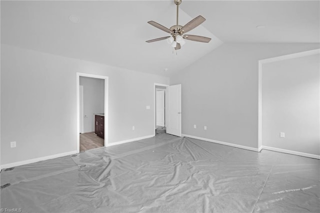 unfurnished bedroom with ensuite bathroom, vaulted ceiling, and ceiling fan