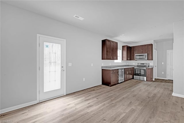 kitchen with dark brown cabinets, stainless steel appliances, light hardwood / wood-style flooring, and plenty of natural light