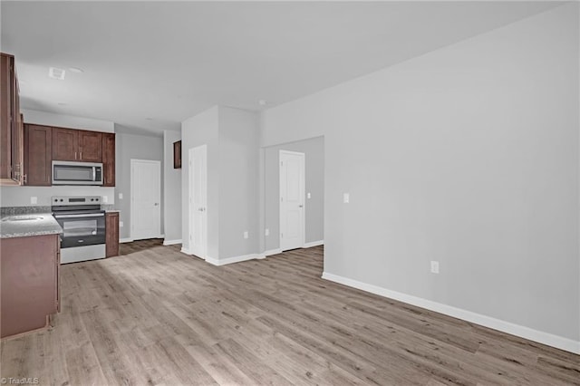 kitchen with stainless steel appliances, light hardwood / wood-style flooring, and sink