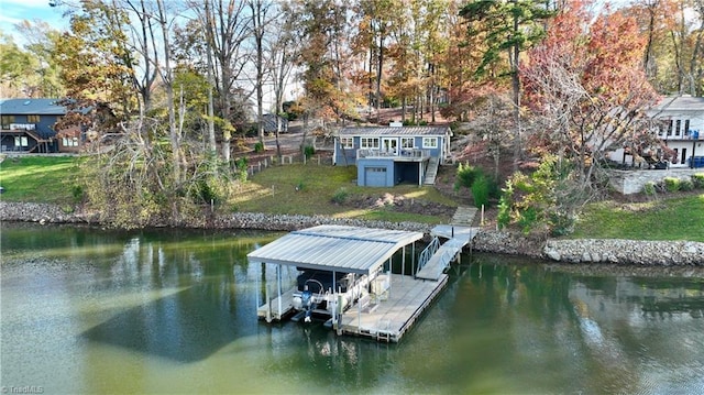 view of dock with a yard and a water view