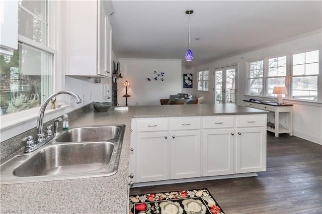 kitchen featuring sink, hanging light fixtures, dark hardwood / wood-style floors, kitchen peninsula, and white cabinets