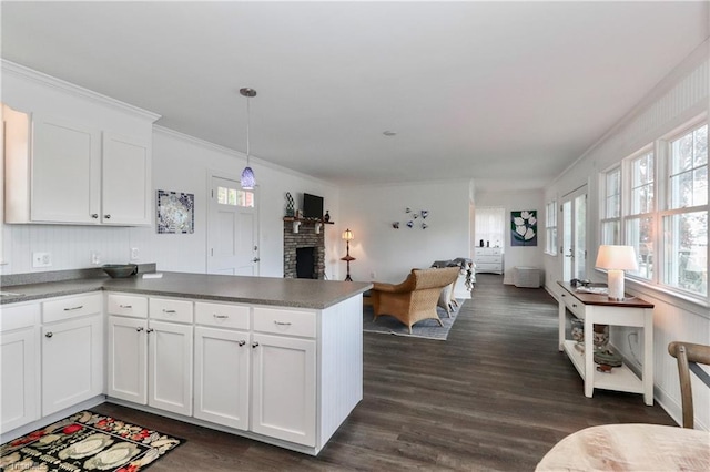 kitchen with decorative light fixtures, white cabinetry, and kitchen peninsula