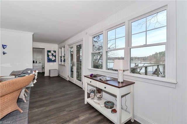 interior space with crown molding, a water view, and dark wood-type flooring