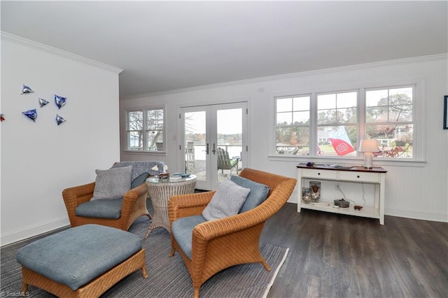 sitting room with a healthy amount of sunlight, dark hardwood / wood-style flooring, ornamental molding, and french doors