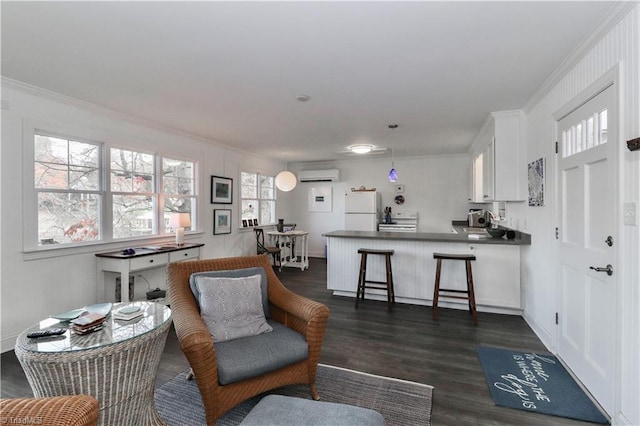 living room with a wall mounted air conditioner, dark hardwood / wood-style floors, a healthy amount of sunlight, and crown molding