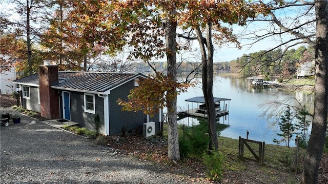 exterior space featuring a dock, ac unit, and a water view