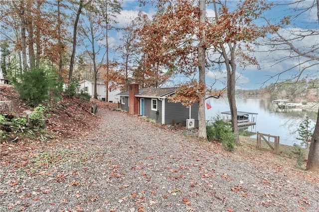 view of side of home featuring a dock and a water view