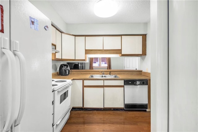 kitchen featuring dark hardwood / wood-style floors, sink, a textured ceiling, and white appliances