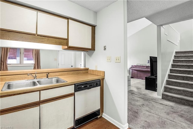 kitchen with white dishwasher, sink, a textured ceiling, and white cabinets