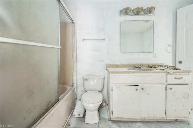 full bath featuring vanity, bath / shower combo with glass door, and toilet