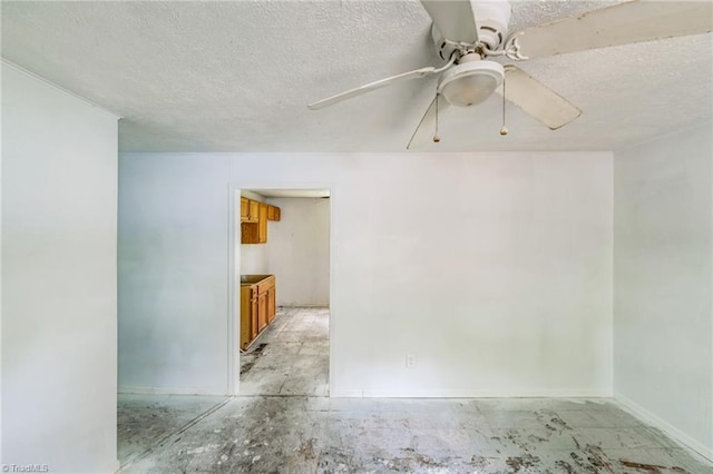 spare room featuring a textured ceiling, baseboards, and ceiling fan