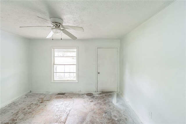 empty room with a textured ceiling, baseboards, and ceiling fan