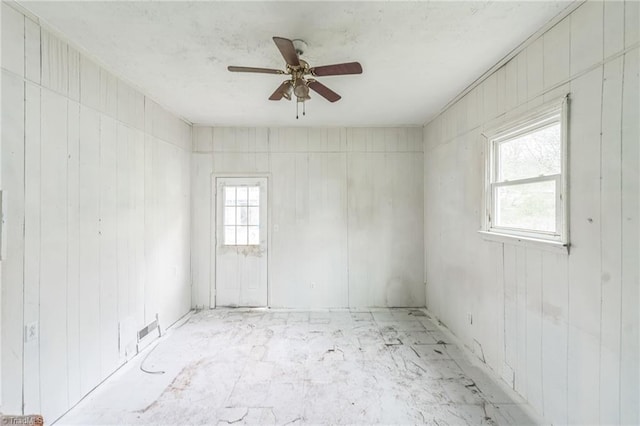 spare room with ceiling fan, visible vents, and plenty of natural light