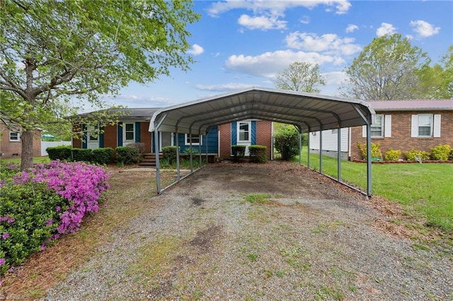view of front of house with a carport, driveway, brick siding, and a front yard