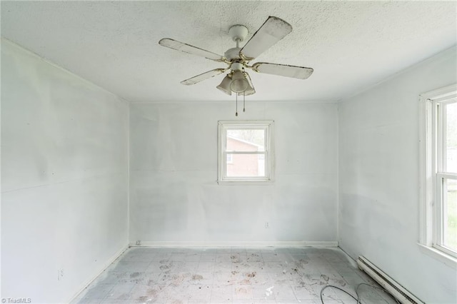 spare room with a textured ceiling, baseboards, baseboard heating, ceiling fan, and light floors