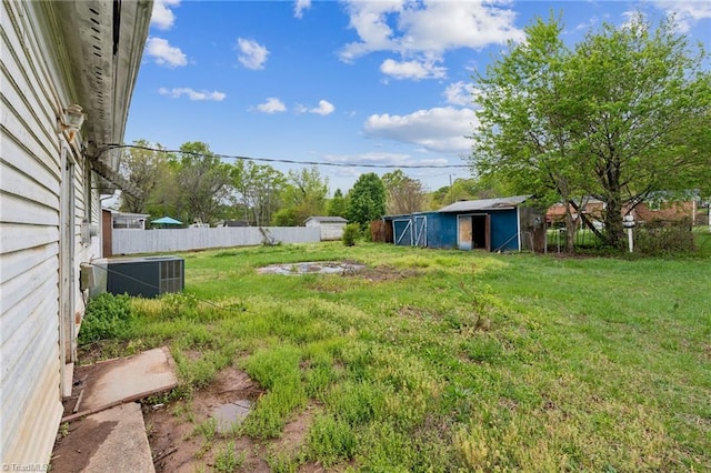 view of yard featuring fence, an outdoor structure, a storage shed, and cooling unit