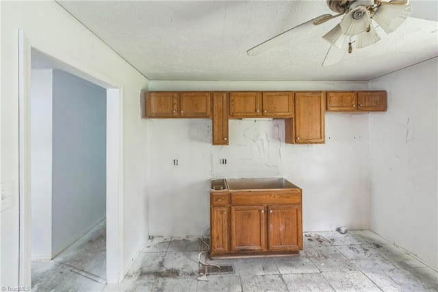 washroom featuring a textured ceiling, a ceiling fan, and a sink
