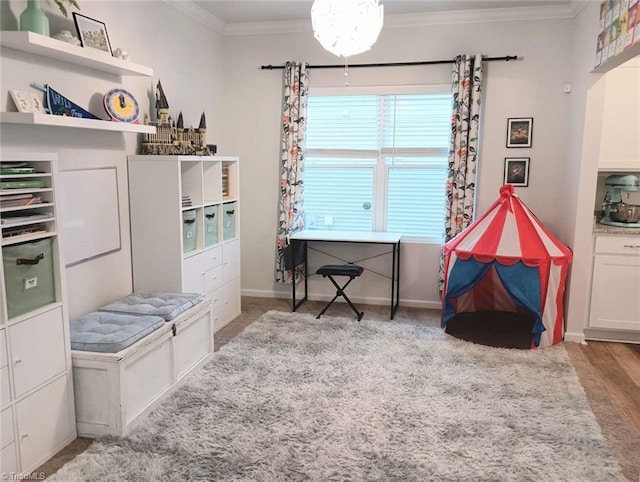 interior space with crown molding, wood finished floors, and baseboards