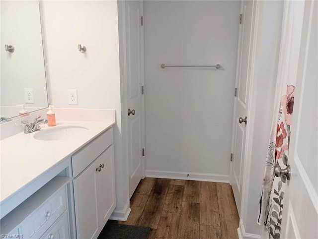 bathroom featuring vanity, baseboards, and wood finished floors