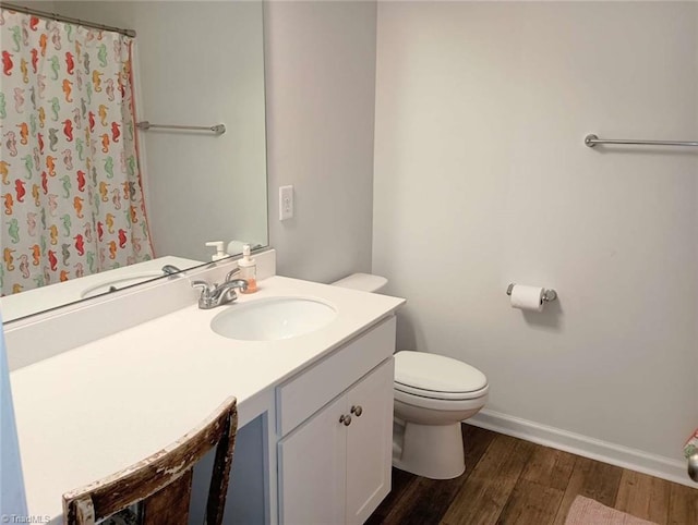 full bathroom with toilet, curtained shower, wood finished floors, baseboards, and vanity