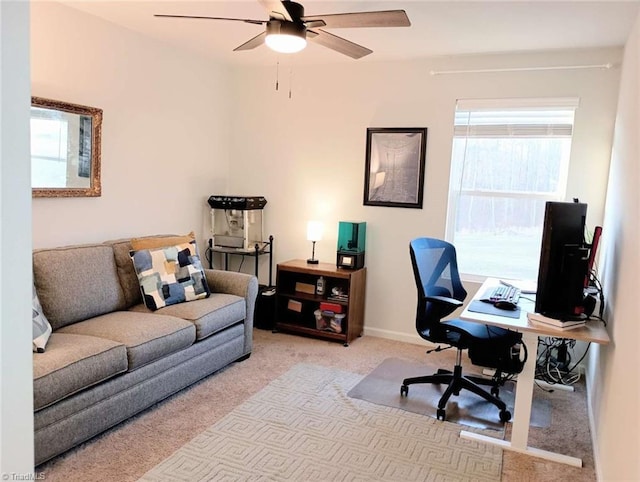 carpeted office with baseboards and a ceiling fan