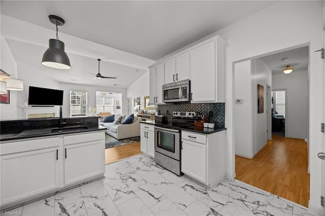116 Maryland Dr, Thomasville, NC 27360 - kitchen with stainless steel appliances, dark countertops, light marble finish flooring, and white cabinetry