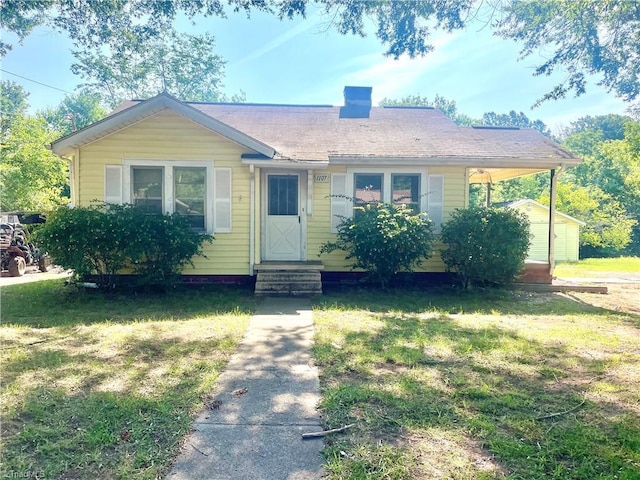 1107 Walnut St, Reidsville, NC 27320 - view of front of home with a chimney, a front yard, entry steps, and a carport