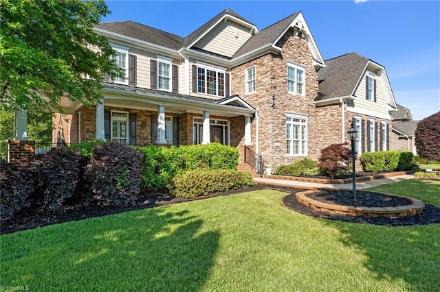 8501 Julina Dr, Oak Ridge, NC 27310 - craftsman inspired home featuring a front lawn, stone siding, roof with shingles, and brick siding