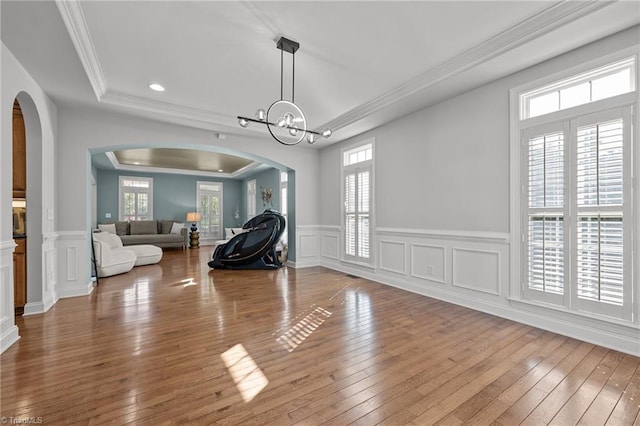 8501 Julina Dr, Oak Ridge, NC 27310 - dining space with arched walkways, healthy amount of natural light, crown molding, wainscoting, and hardwood / wood-style floors