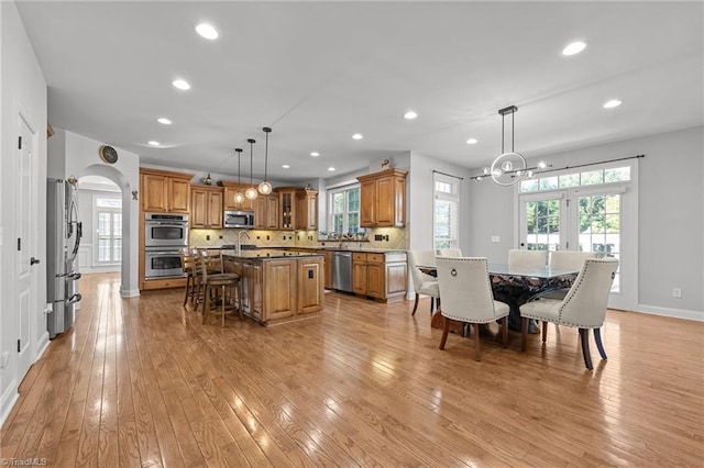 8501 Julina Dr, Oak Ridge, NC 27310 - dining room with recessed lighting, a chandelier, arched walkways, light wood-style flooring, and baseboards