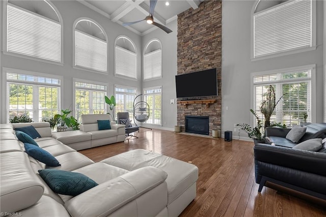 8501 Julina Dr, Oak Ridge, NC 27310 - living area featuring a high ceiling, hardwood / wood-style flooring, a stone fireplace, beamed ceiling, and ceiling fan