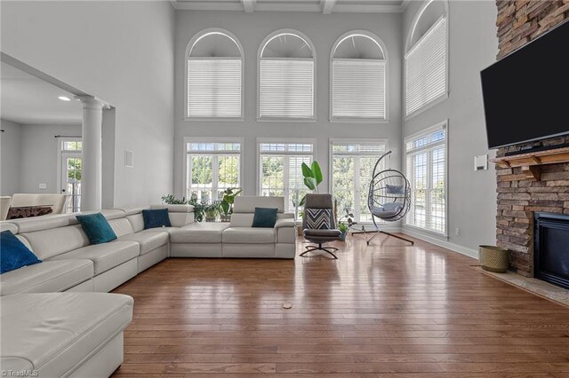 8501 Julina Dr, Oak Ridge, NC 27310 - living room featuring a fireplace, hardwood / wood-style floors, decorative columns, beam ceiling, and ornamental molding