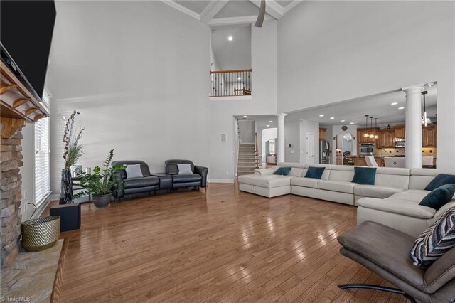 8501 Julina Dr, Oak Ridge, NC 27310 - living area featuring ornate columns, a towering ceiling, light wood-style flooring, ornamental molding, and baseboards