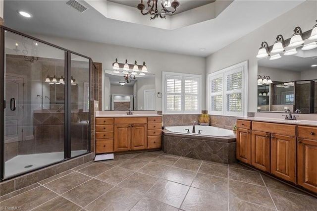 8501 Julina Dr, Oak Ridge, NC 27310 - bathroom with a chandelier, a bath, a stall shower, tile patterned flooring, and two vanities