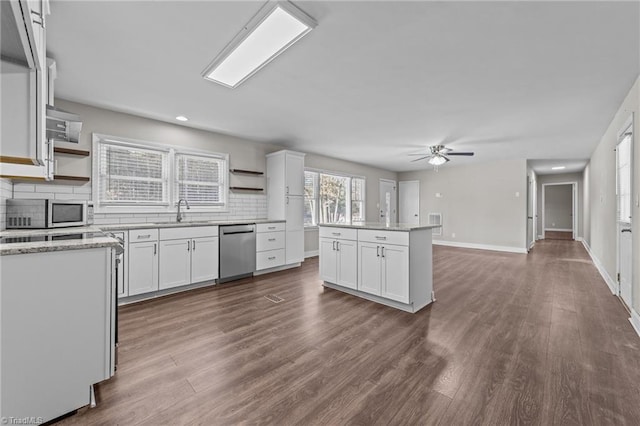 kitchen featuring sink, white cabinets, tasteful backsplash, a kitchen island, and appliances with stainless steel finishes