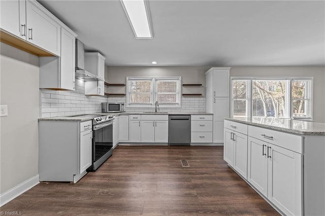 kitchen with sink, stainless steel appliances, white cabinetry, and light stone countertops