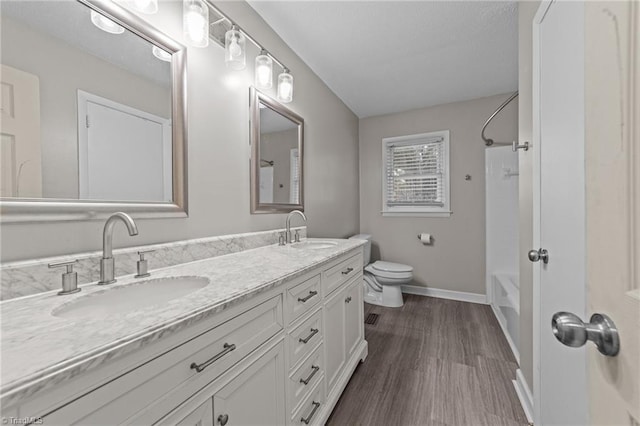 full bathroom featuring hardwood / wood-style floors,  shower combination, vanity, and toilet