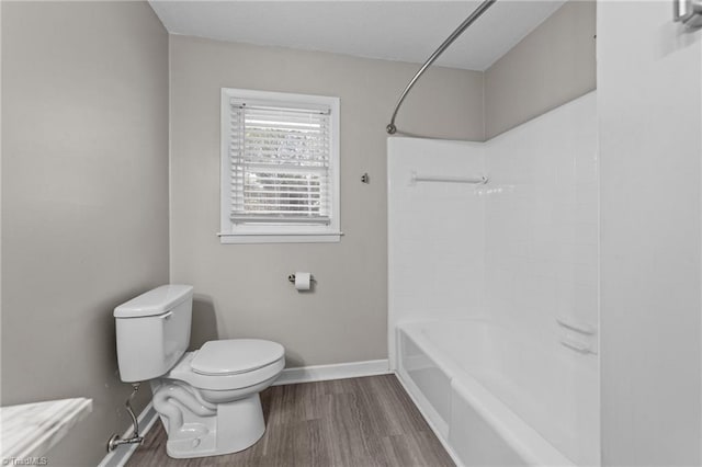 bathroom featuring toilet, hardwood / wood-style flooring, and shower / bathing tub combination