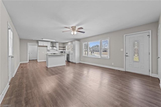 unfurnished living room with ceiling fan and dark hardwood / wood-style floors