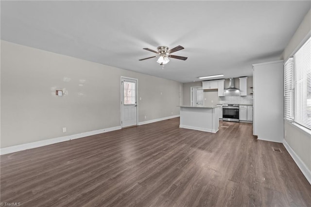 unfurnished living room with ceiling fan, plenty of natural light, and dark hardwood / wood-style floors