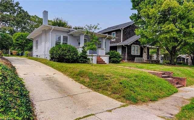 bungalow-style home featuring a front yard and a chimney