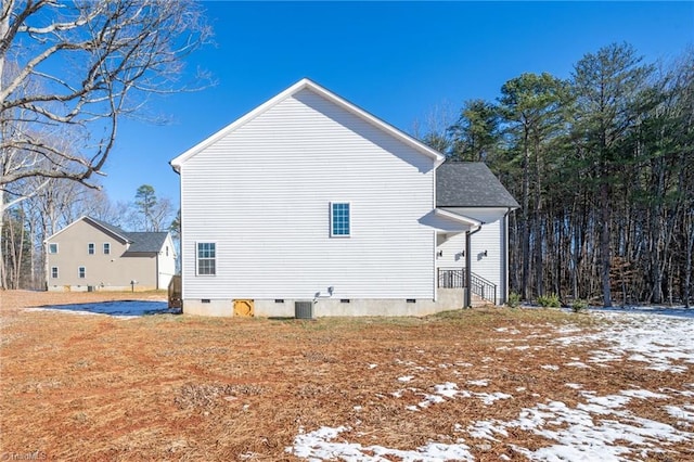 snow covered property with central air condition unit