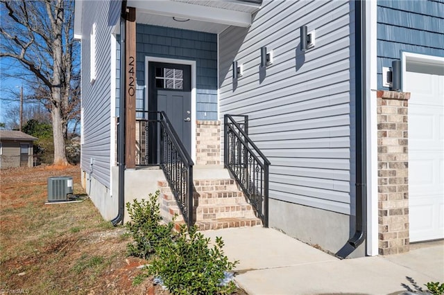 doorway to property featuring a garage and cooling unit