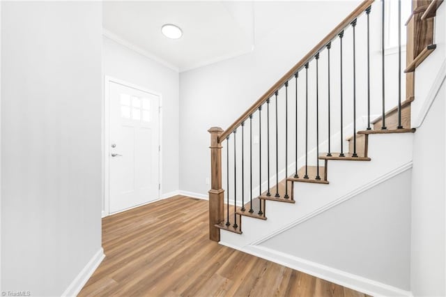 entrance foyer with ornamental molding and hardwood / wood-style flooring