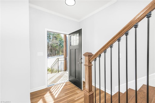 entryway with ornamental molding and light hardwood / wood-style flooring