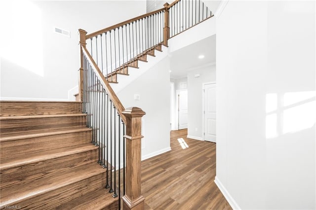 stairway featuring ornamental molding and hardwood / wood-style floors